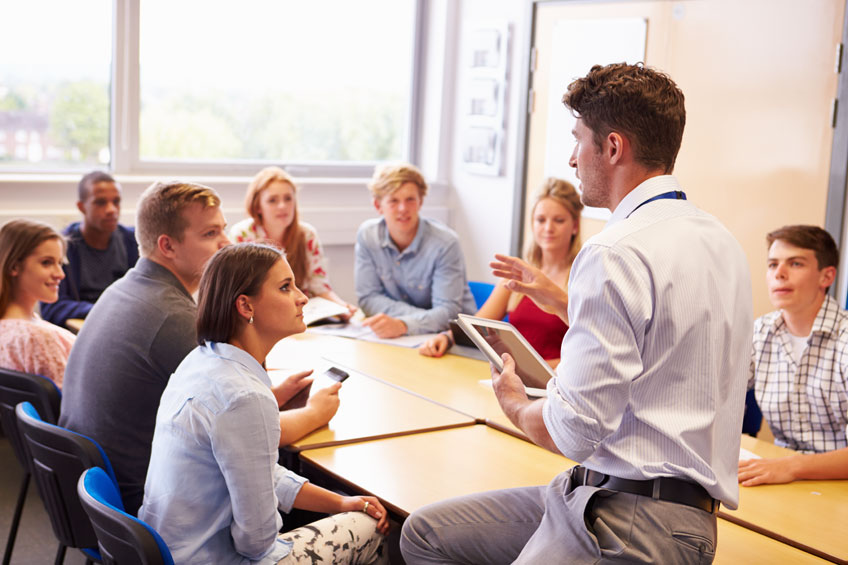 Students practising English conversation in a classroom